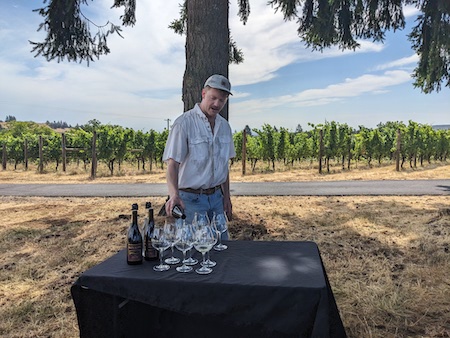 A man pouring wine in Bryn Mawr's vineyard